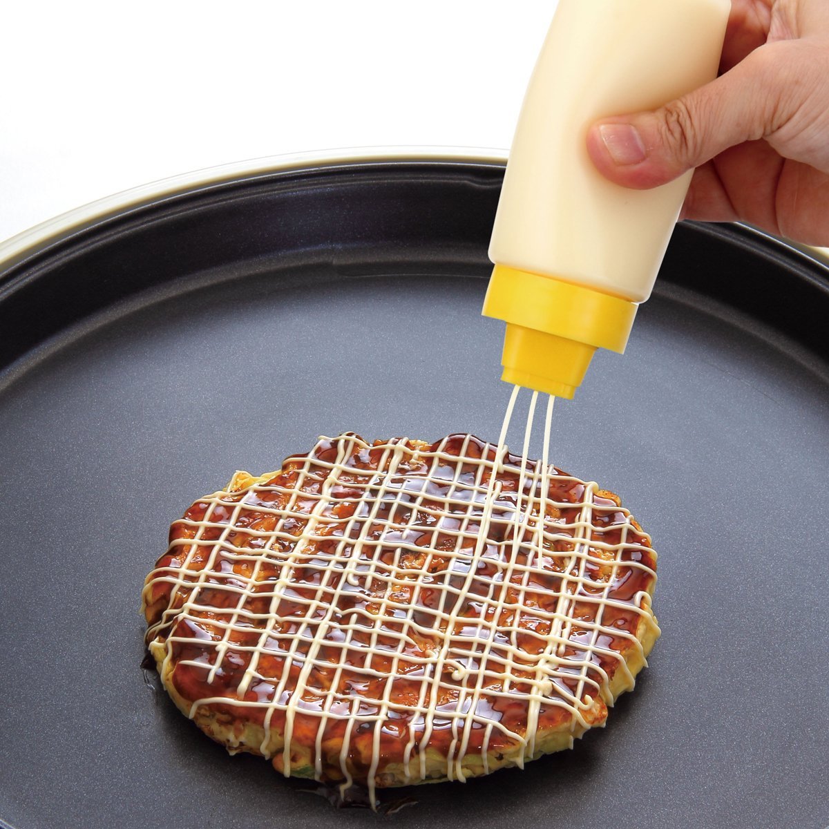 4-Hole Squeeze Sauce Bottle being used on pancake in pan