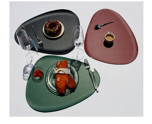 Red, black and green leather look oval placemats with cutlery and crockery