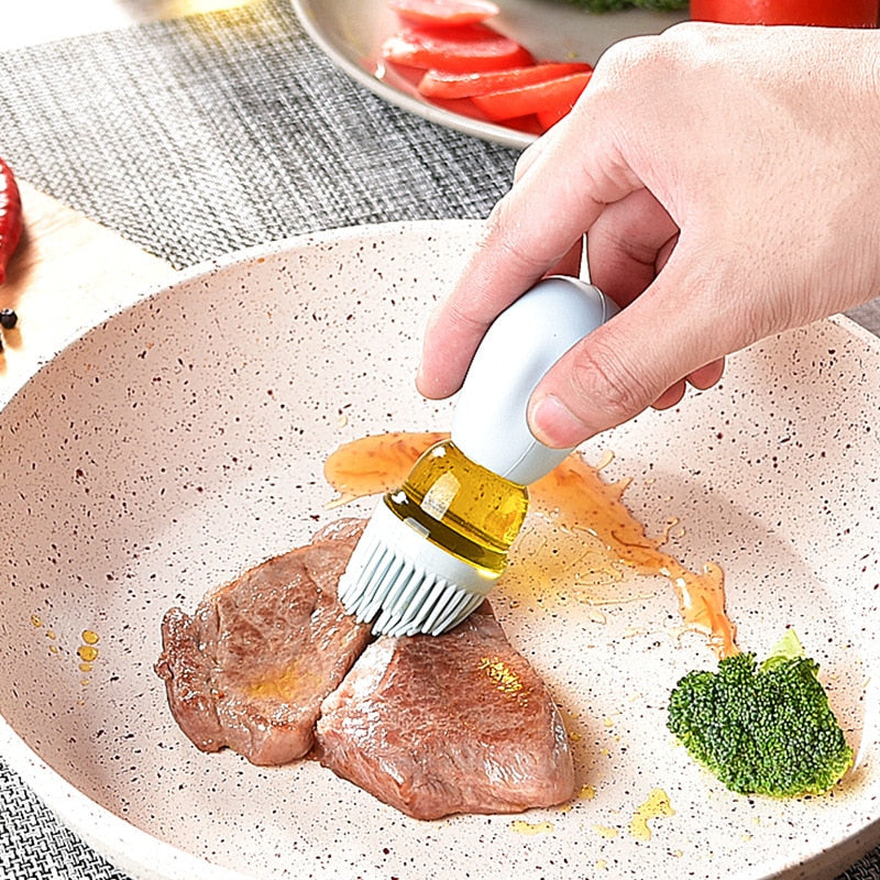 Silicone glass oil container being used to put oil on a piece of meat